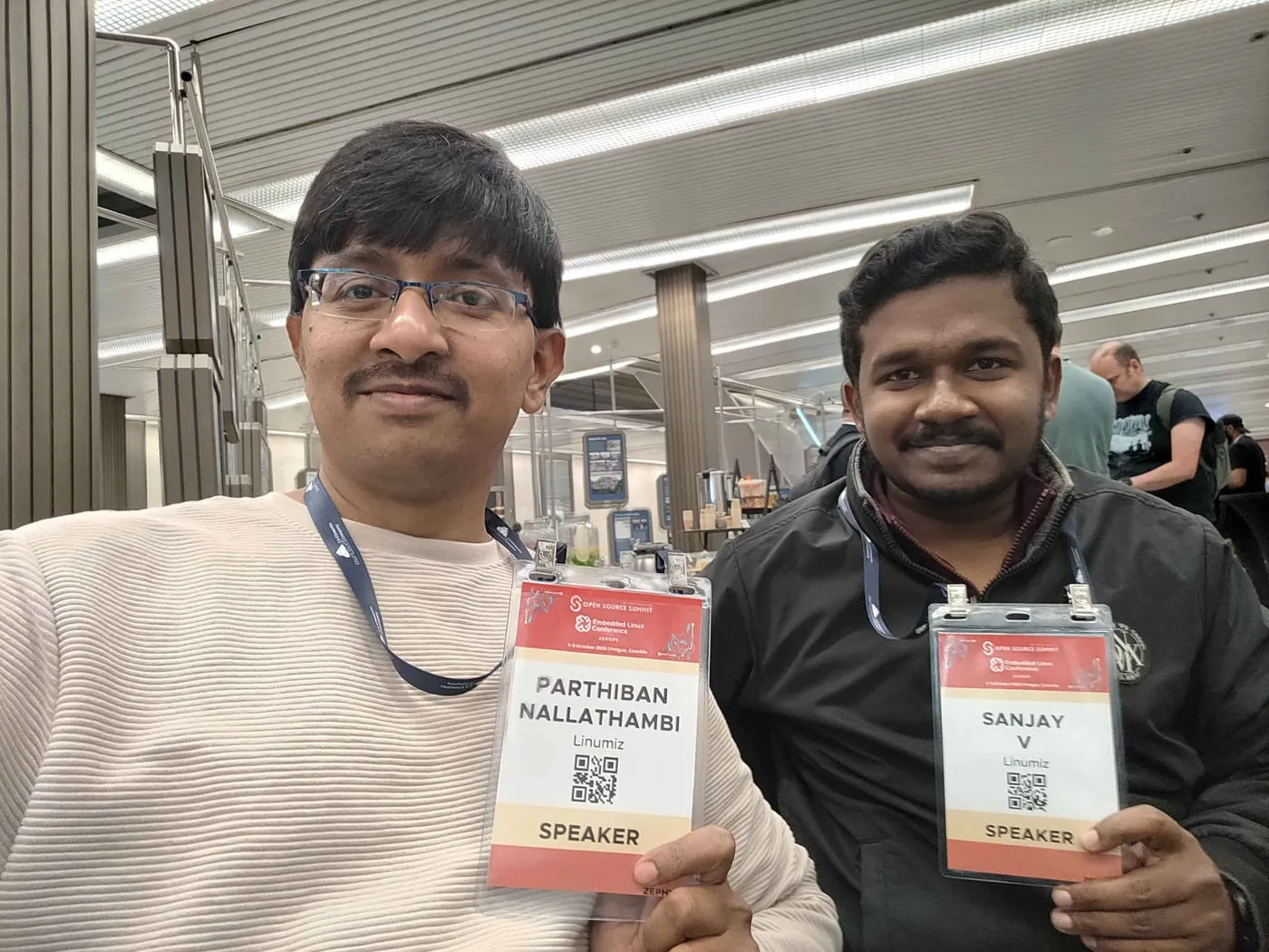 Parthiban Nallathambi and Sanjay Vallimanalan of Linumiz holding their Open Source Summit Europe speaker badges at the Prague Congress Centre